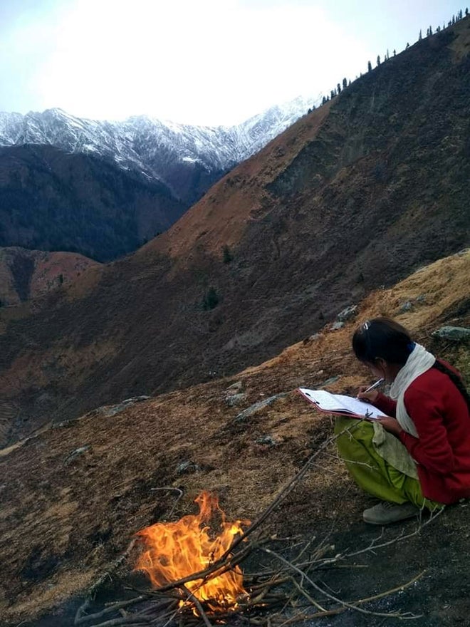A girl takes an online exam on the top of a mountain in Bharmour, Chamba, HP